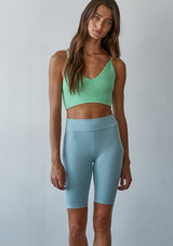 [Color: Mint Parfait] A front facing image of a brunette model wearing a basic lime green bralette cami with a slim stretchy fit and a v neckline.