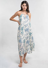 [Color: Ocean/Blue] A front facing image of a brunette model wearing a blue and white floral sleeveless halter maxi dress with a relaxed, flowy silhouette. Styles with brown strappy sandals. 