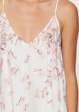 [Color: Blue Rose/Vanilla] A detail image of a brunette model wearing a bohemian white and pink butterfly print maxi dress with a v neckline and adjustable spaghetti straps. 