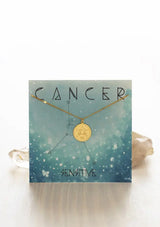 [Zodiac Sign: Cancer] Gold necklace on an Cancer-themed card with celestial design