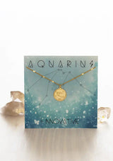 [Zodiac Sign: Aquarius] Gold necklace with Aquarius zodiac design on a matching card with decorative elements.