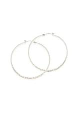[Color: Silver] A pair of large, thin silver hoop earrings with a hammered texture.