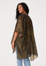 [Color: Gold/Dark Indigo] A back facing image of a brunette model wearing a gold bohemian duster kimono with a dark indigo velvet burnout design. A special occasion kimono with half length sleeves and an open front. 
