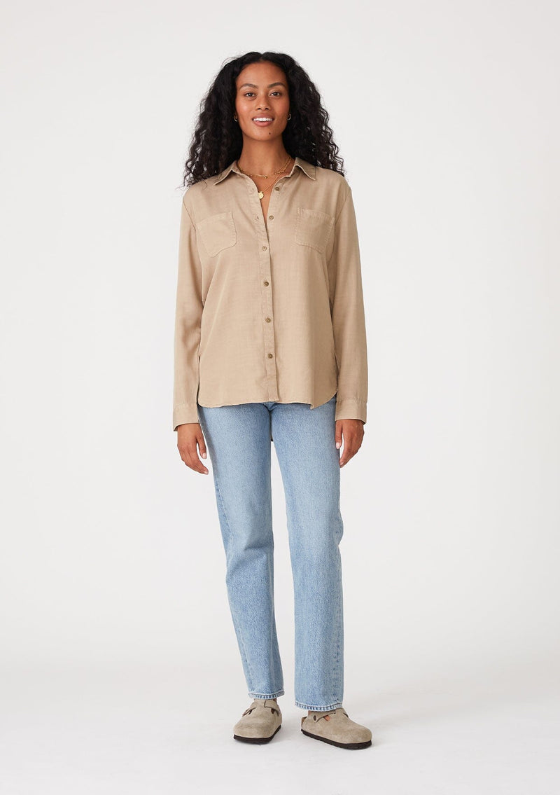 [Color: Sand] A front facing image of a brunette model wearing a relaxed fit khaki shirt. With long sleeves, a collared neckline, a button front, and front patch pockets. 