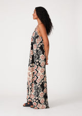 [Color: Black/Dusty Rose] A side facing image of a brunette model wearing a best selling black and pink bohemian printed maxi dress. With adjustable spaghetti straps, a deep v neckline in front and back, a flowy, oversize cocoon fit, and side pockets.