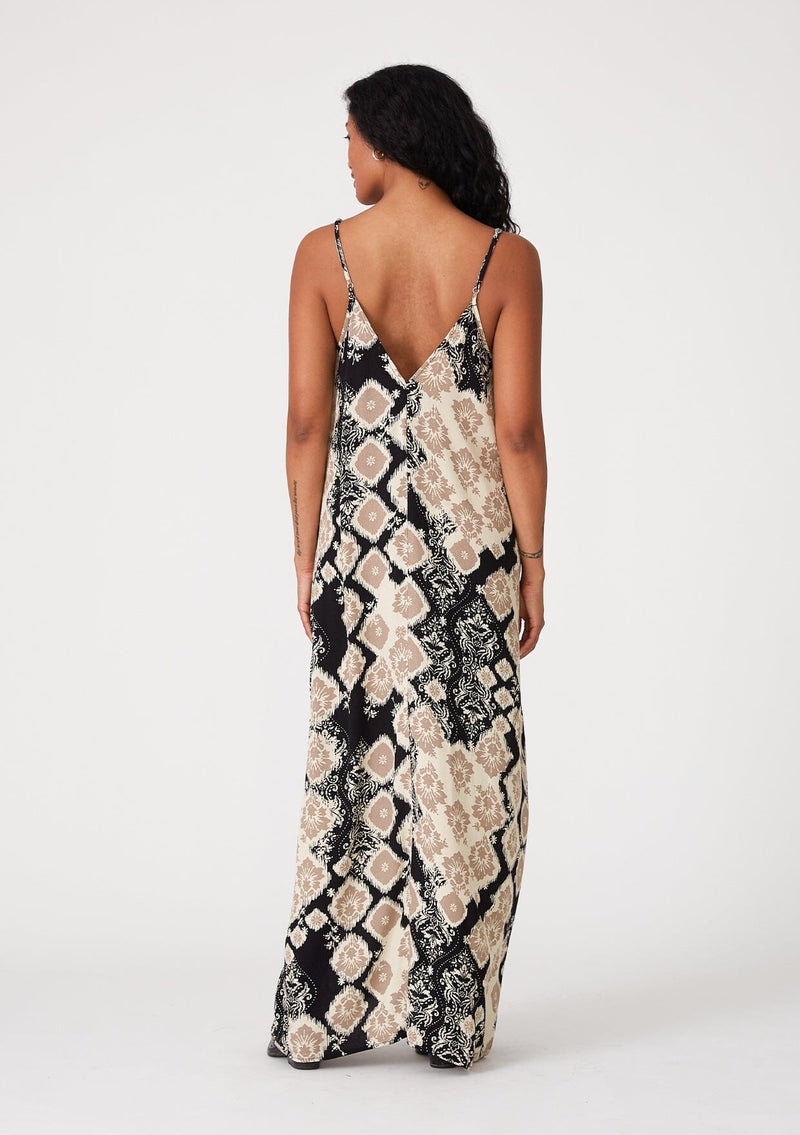 [Color: Black/Khaki] A back facing image of a brunette model wearing a best selling black and beige bohemian printed maxi dress. With adjustable spaghetti straps, a deep v neckline in front and back, a flowy, oversize cocoon fit, and side pockets.