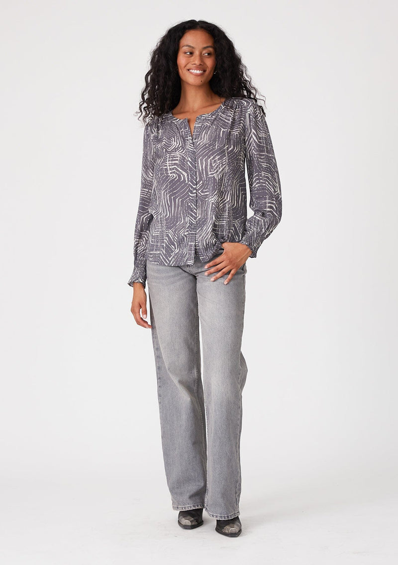 [Color: Grey/Cream] A full body front facing image of a brunette model wearing a bohemian fall blouse in an abstract grey print. With long sleeves, a round neckline, and a self covered button front. 