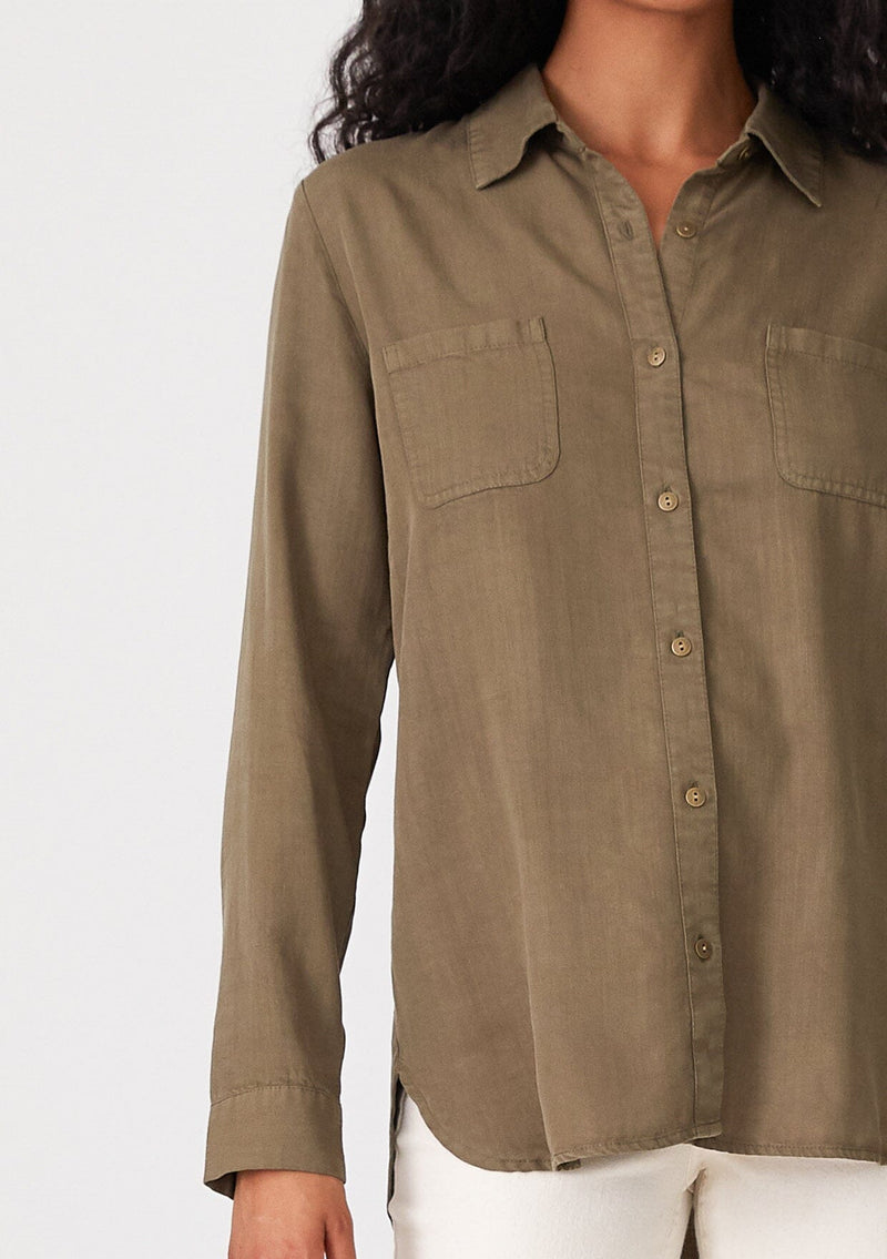 [Color: Military] A close up front facing image of a brunette model wearing a relaxed fit olive green shirt. With long sleeves, a collared neckline, a button front, and front patch pockets. 