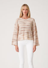 [Color: Dusty Blush] A front facing image of a blonde model wearing a cropped bohemian sweater in a pink and brown multi color space dye knit. With long bell sleeves and a wide boat neckline.