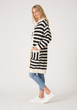 [Color: Black/White] A side facing image of a blonde model wearing a mid length cardigan in a black and white stripe. With long sleeves, a collared neckline, an open front, and side pockets.