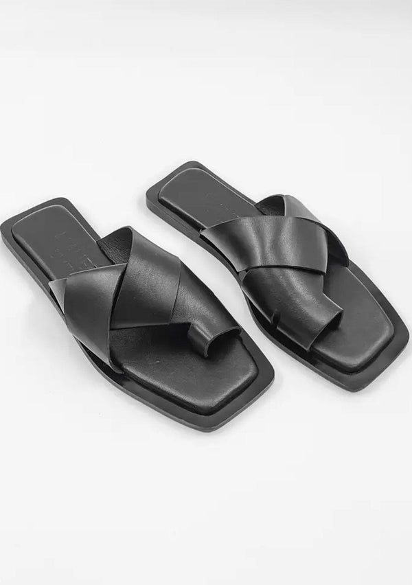 [Color: Black] A simple and sophisticated black leather flat slip on sandal with a toe hold. 