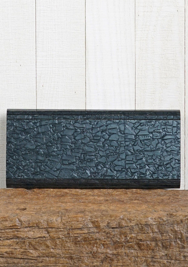[Color: Black Pearl] A pearlescent clutch made from molded resin. Features a magnetic closure.