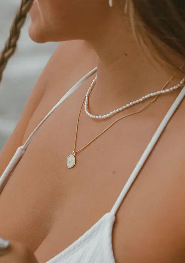 A dainty freshwater pearl necklace made with fourteen karat gold plated on sterling silver. Hypoallergenic and made in the USA.