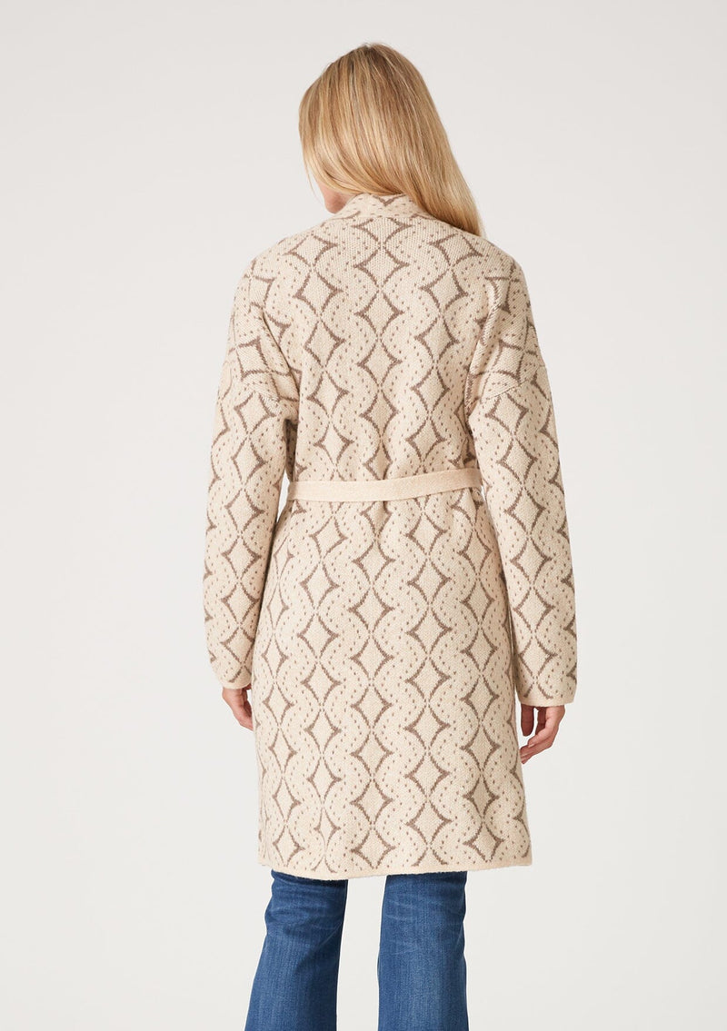 [Color: Natural/Taupe] A back facing image of a blonde model wearing a soft mid length cardigan sweater coat in an ivory diamond jacquard. With long sleeves, side pockets, and a belted tie waist.