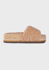[Color: Sand] An image of a fuzzy shearling slide sandal in beige with a thick platform sole. Designed with sustainability in mind from Fleks footwear. 