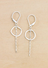 Pair of silver earrings with a small hammered circle and chain drop detail. Attached to a round wire lever back. 