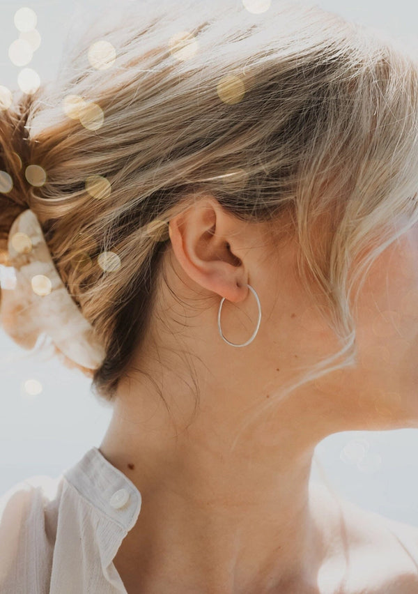 Sterling silver hoop earrings hammered into an imperfect circle.