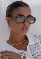 [Color: Milky Tortoise] A woman wearing round sunglasses with a tortoise frame from FREYRS.