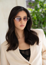 [Color: Gold/Lavender] A woman wearing gold metal and tortoise frame glasses with lavender lenses from FREYRS.