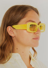[Color: Pineapple] A pair of rectangle, yellow frames with transition day to night lenses. Made by INDY