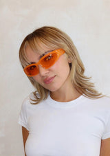 [Color: Orange] A pair of sporty, thick bright orange frames with amber orange lenses. Made by INDY