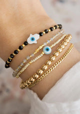 [Title: Black Onyx]  An adjustable healing bracelet, crafted on a durable nylon cord with a mother of pearl hamsa stone, gold-plated hardware and black natural gemstones. Designed by Kindred Row.