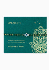 [Title: Malachite]  An adjustable healing bracelet, crafted on a durable nylon cord with a mother of pearl hamsa stone, gold-plated hardware and green natural gemstones. Designed by Kindred Row.