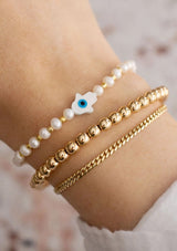 [Title: Pearl]  An adjustable healing bracelet, crafted on a durable nylon cord with a mother of pearl hamsa stone, gold-plated hardware and pearl white natural gemstones. Designed by Kindred Row.