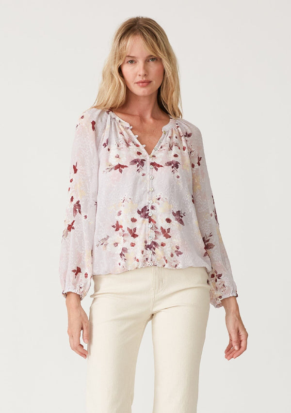 [Color: Dusty Blush/Wine] A front facing image of a blonde model wearing a bohemian resort blouse crafted from textured chiffon and designed in a pink floral print. With a decorative button front, a v neckline, long raglan sleeves, and an elastic waist. 