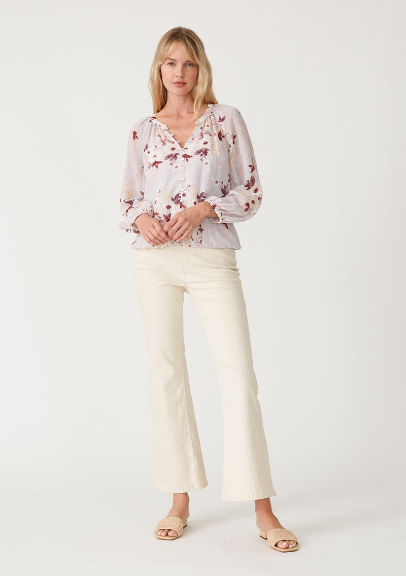 [Color: Dusty Blush/Wine] A full body front facing image of a blonde model wearing a bohemian resort blouse crafted from textured chiffon and designed in a pink floral print. With a decorative button front, a v neckline, long raglan sleeves, and an elastic waist. 