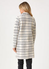 [Color: Cream/Black] A back facing image of a blonde model wearing a fuzzy statement sweater coat in a cream and black plaid print. With long sleeves, a notched collar, a snap button front, and side patch pockets. 