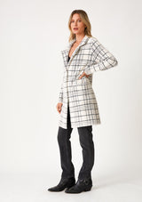 [Color: Cream/Black] A full body side facing image of a blonde model wearing a fuzzy statement sweater coat in a cream and black plaid print. With long sleeves, a notched collar, a snap button front, and side patch pockets. 