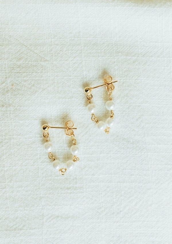 Delicate chain hoop earrings with freshwater pearls. Crafted from fourteen karat gold on sterling silver base, these beachy earrings are hypoallergenic and tarnish resistant. 