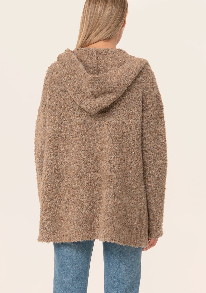 [Color: Mocha] A back facing image of a blonde model wearing a fuzzy brown boucle hooded cardigan. With long sleeves and an open front.