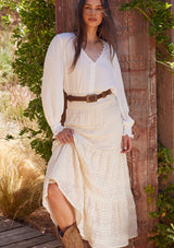 [Color: Natural] A front facing image of a brunette model wearing a bohemian off white lace maxi skirt.