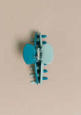 [Color: Robin] A two tone turquoise medium sized hair clip by Nat and Noor. 