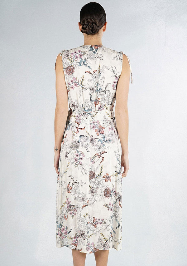 [Color: Natural Combo] An off white bohemian mid length wrap dress in a sketched floral print. With tie shoulder detail, a side tie closure at the waist, and a ruffled overlay at the bodice. 