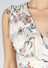[Color: Natural Combo] An off white bohemian mid length wrap dress in a sketched floral print. With tie shoulder detail, a side tie closure at the waist, and a ruffled overlay at the bodice. 
