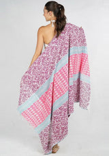 [Color: Mauve] A cotton beach towel showcasing a purple and pink botanical and geometric patchwork print, complete with a double-sided design and fringe accents.