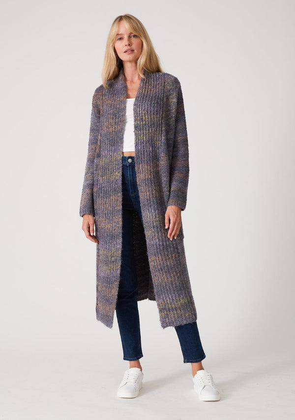 [Color: Denim Multi] A front facing image of a blonde model wearing a multi color blue knit long duster cardigan. A bohemian sweater coat with long sleeves, an open front, side pockets, and a rollover collar.