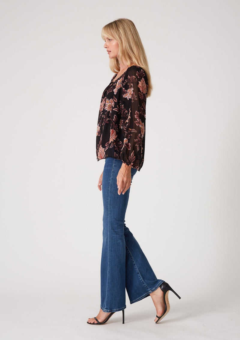 [Color: Black/Dusty Coral] A half body side facing image of a blonde model wearing a flowy bohemian sheer chiffon blouse in a black and coral floral print. With voluminous long sleeves, a split v neckline with ties, and a wide round elastic neckline.