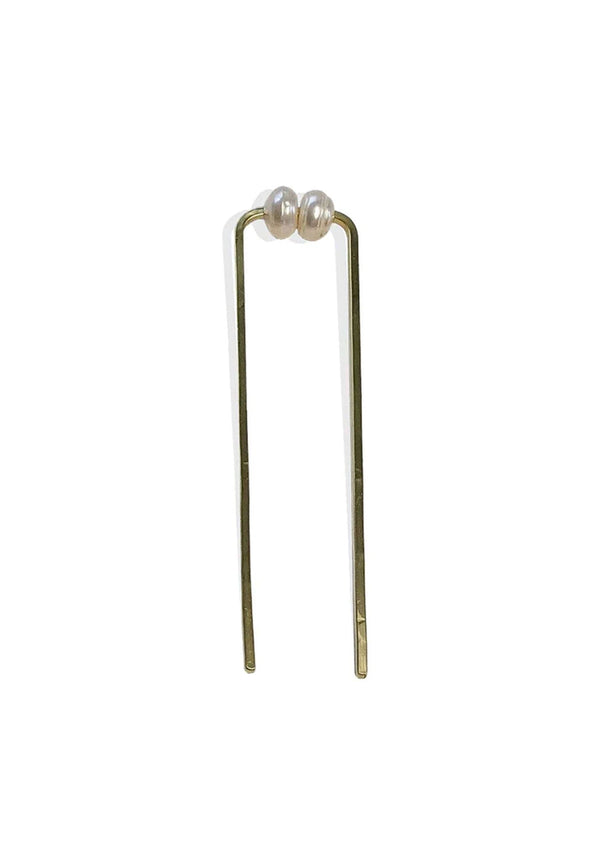 [Color: Cream] A chunky brass hair fork with a cream pearl accent. 