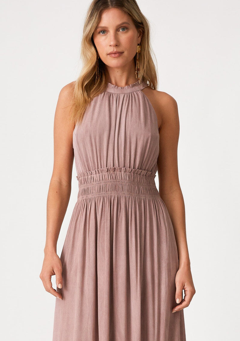 [Color: Rose Water] A close up front facing image of a blonde model wearing a pink bohemian maxi dress in a soft pink vintage wash. With a ruffle trimmed halter neckline, a smocked elastic waist, a tiered long skirt, and a back keyhole detail with an adjustable tie. 
