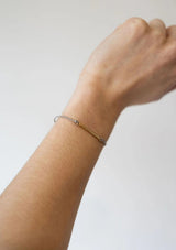 [Color: Storm Grey] Dainty gold bar bracelet with an adjustable grey cord 