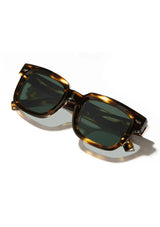 [Color: Jaguar] Sunglasses with a warm grey lens and a brown tortoise acetate frame.