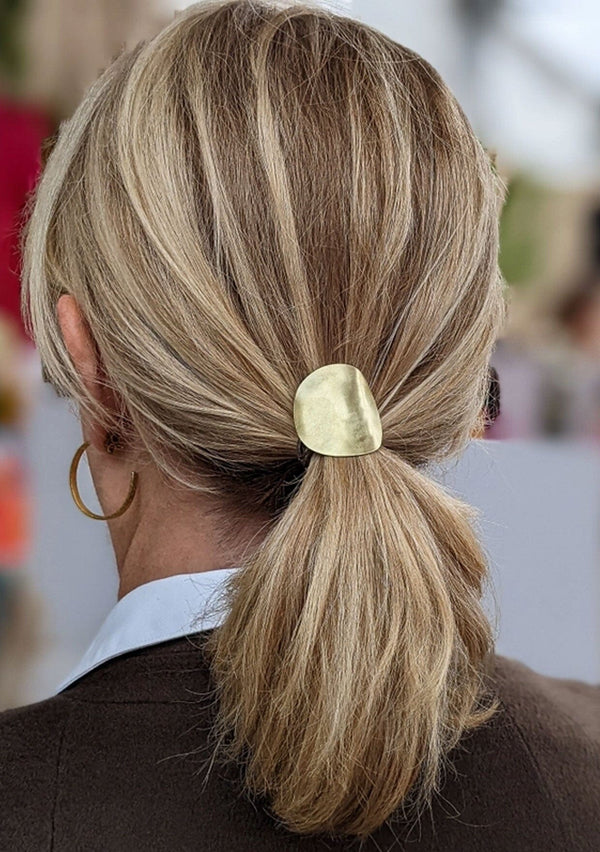[Color: Brass] A sculptural brass ponytail holder with interchangeable hair elastic, made in the USA.