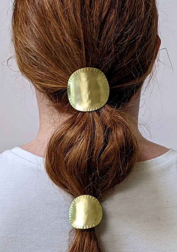 [Color: Brass] A hand stamped oval brass ponytail holder with interchangeable hair elastic. Hand made in the USA.