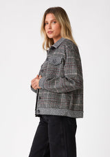 [Color: Wine/Black] A side facing image of a blonde model wearing a classic bohemian shirt jacket in a black and red patchwork plaid. A fall shirt jacket with long sleeves, a button front, a collared neckline, front patch flap pockets, and side pockets. 