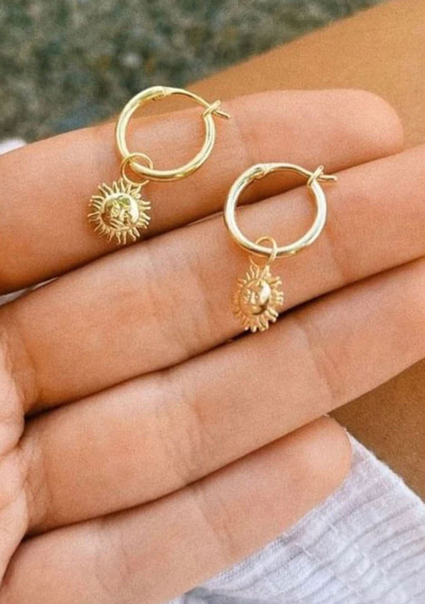 A cool hoop earring with a dainty sun charm. Made with fourteen karat gold plating on sterling silver. Hypoallergenic and made in the USA. 