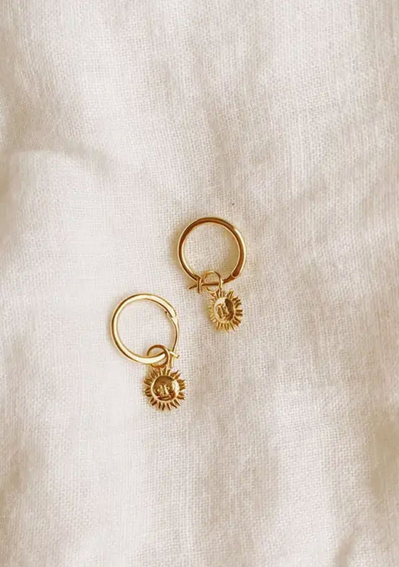 A cool hoop earring with a dainty sun charm. Made with fourteen karat gold plating on sterling silver. Hypoallergenic and made in the USA. 